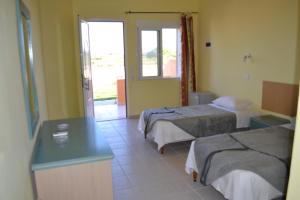 PhanaesTo Akrogiali的酒店客房设有两张床和一张桌子。