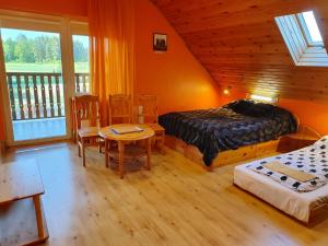 IkšķileKaķumuiža的卧室配有一张床和一张桌子及椅子