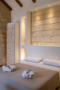 博尔加涅Agriturismo Masseria Costarella的一间卧室配有两张带毛巾和镜子的床
