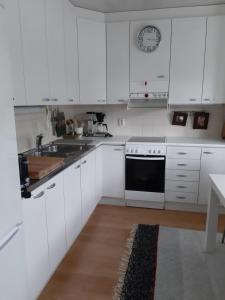 萨翁林纳Peltorinne 14的白色的厨房配有白色橱柜和水槽