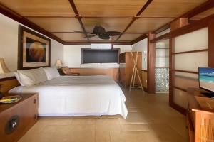 科洛阿Kuhio Shores 316的一间卧室配有一张床和吊扇