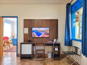 博尼图Pousada Ouro Preto de Bonito的客房设有一张桌子,墙上配有电视