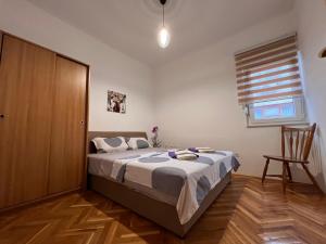 莫斯塔尔DALIA Apartment & Room的一间卧室配有一张床,铺有木地板