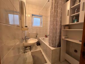 莫斯塔尔DALIA Apartment & Room的浴室配有盥洗盆、卫生间和浴缸。