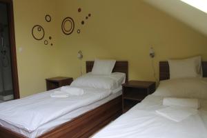 杰尔Pótkerék Motel的两张睡床彼此相邻,位于一个房间里