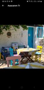 CumalıGüneş Butik Otel Datça的一个带蓝色门的庭院里的野餐桌和椅子