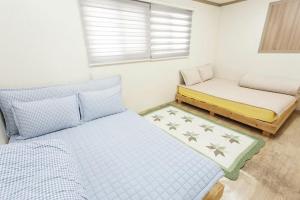 全州市Danaharu Guesthouse的一间带两张床和长凳的小卧室