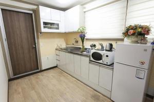 全州市Danaharu Guesthouse的厨房配有白色冰箱和微波炉