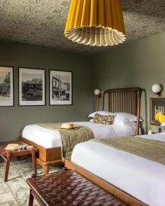 奥兰治The Richland的一间卧室配有两张床和吊灯。