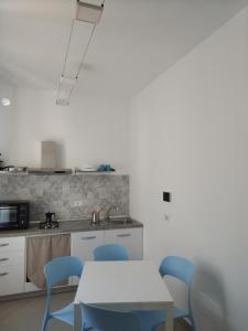 米拉佐LA REGGIA APARTMENTS MILAZZO的厨房配有桌子和蓝色的椅子