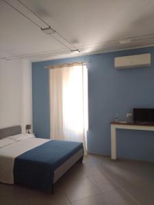 米拉佐LA REGGIA APARTMENTS MILAZZO的一间卧室配有一张蓝色墙壁和窗户的床