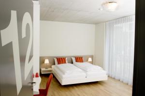 苏黎世亨齐克住宿加早餐旅馆的白色的卧室设有床和窗户