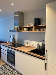 ĶesterciemsPiejūras apartaments的厨房配有白色橱柜和炉灶烤箱。