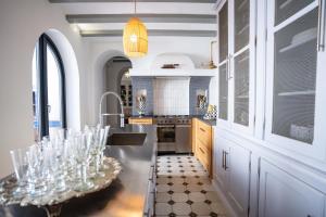 GodellaValencia Luxury Guest House的厨房配有水槽和带酒杯的桌子
