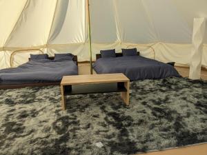 美作Glamchette Okayama -Glamping & Auto Camp- - Vacation STAY 44605v的帐篷内的两张床和一张桌子