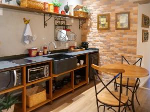 蒂拉登特斯Lofts Villa da Serra的厨房配有水槽和桌椅