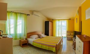 罗戈兹尼察Apartments Mikulić的一间卧室设有床、黄色的墙壁和窗户