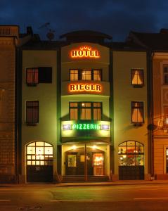 伊钦Hotel Rieger Garni的前面有 ⁇ 虹灯标志的酒店