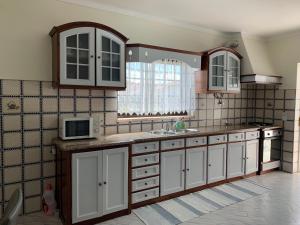纳扎雷Casa Buzina的厨房配有白色橱柜、水槽和微波炉