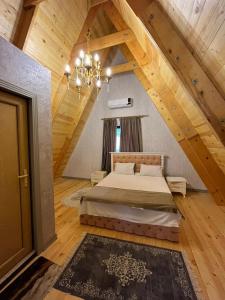 盖贝莱Qafqaz house的阁楼上配有1张床铺的卧室,配有吊灯