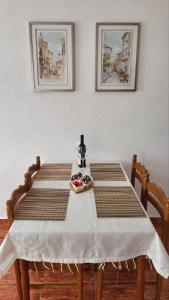 KraljevićiGazdinstvo Kraljevic的一张桌子,上面有两把椅子和一张白色的桌布