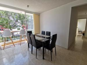 布卡拉曼加Mi hogar - Apartamento familiar en Bucaramanga的一间带桌椅和大窗户的用餐室