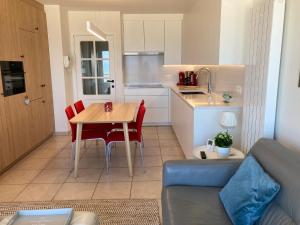 奥斯坦德Apartment "Zeezicht"的厨房以及带桌椅的用餐室。