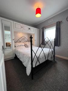 比迪福德20 Bucklands, Bideford Bay Holiday Park的一间卧室配有一张床和红灯
