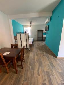 埃斯孔迪多港Casa Suites Minizoo的配有桌椅和蓝色墙壁的客房