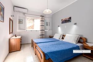 帕莱欧卡斯提撒Matsas House & Studio的一间卧室配有一张带蓝色毯子的床