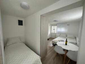 莫伊科瓦茨Pejovic apartmani Mojkovac的一间卧室配有一张床和一张桌子及一瓶葡萄酒