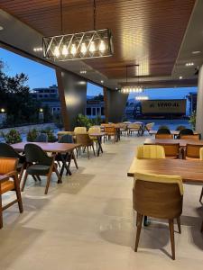 乌尔齐尼Trio Resort的餐厅设有桌椅和许多桌子
