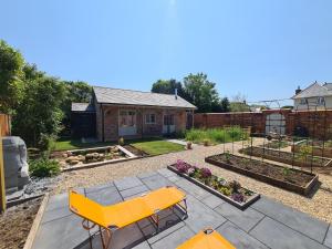 基督城Dragonfly cottage的后院设有黄色长凳和花园