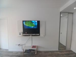 布宜诺斯艾利斯@juanbjustoapartamento的客房内白色墙壁上的平面电视