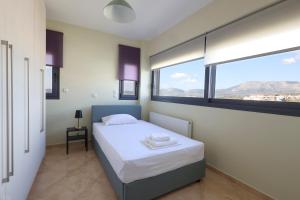 斯巴达Thea Apartment_Athens Airport的一间卧室设有一张床和一个大窗户