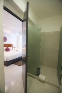 切图马尔TRYP by Wyndham Chetumal的一间带玻璃淋浴的浴室和一张床