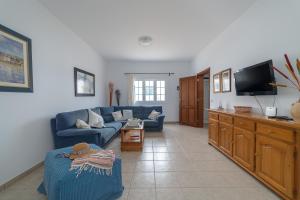 塞博河畔卡莱塔Casa Vlaorda by HH的客厅配有蓝色的沙发和电视