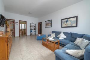 塞博河畔卡莱塔Casa Vlaorda by HH的客厅配有蓝色的沙发和桌子