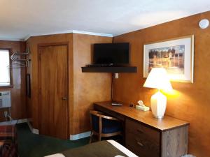 GladstoneGladstone Motel的酒店的客房,设有书桌和墙上的电视