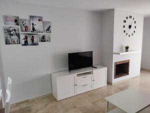 马贝拉Sunny Guadalmina Apartment的一间客厅,在白色的橱柜上配有电视