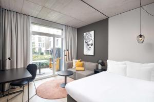 欧普菲康Radisson Hotel & Suites Zurich的一间卧室设有一张床和一间客厅。