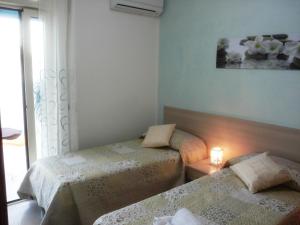托里切拉B&B Trullo di Mare的小型客房 - 带2张床和窗户