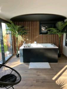 洛翁普拉日ESCAPE ZEN Oasis tropicale & Spa privatif的带浴缸和椅子的大浴室