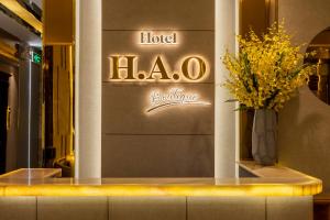 胡志明市H A O Boutique Hotel的酒店大堂,在柜台上放花瓶