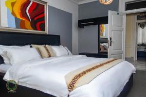 ApenkwaGullivers Travel Hotel的卧室内的一张白色大床,配有绘画作品