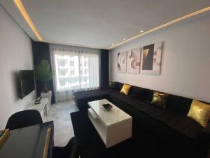 卡萨布兰卡Corniche Casablanca - Black New的客厅配有沙发和桌子