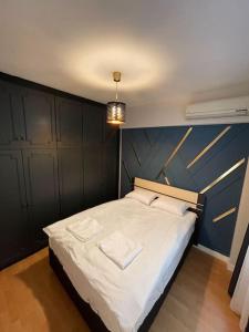 伊斯坦布尔Mükemmel Deniz Manzaralı Lüks的一间卧室设有一张蓝色墙壁的大床