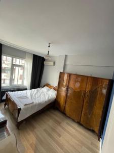 伊斯坦布尔Mükemmel Deniz Manzaralı Lüks的一间卧室配有一张床和一个大型木制橱柜