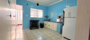 坎皮纳斯Deck Hostel Taquaral的厨房拥有蓝色的墙壁和白色的冰箱。