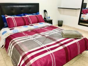 波哥大Dorado Airport rooms & apartments的一间卧室配有一张大床,配有粉红色和紫色的被子